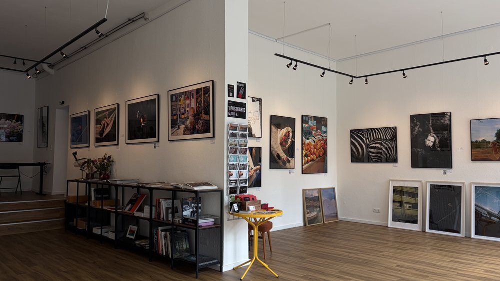 Ausstellungsraum mit Holzboden und gerahmten Fotografien