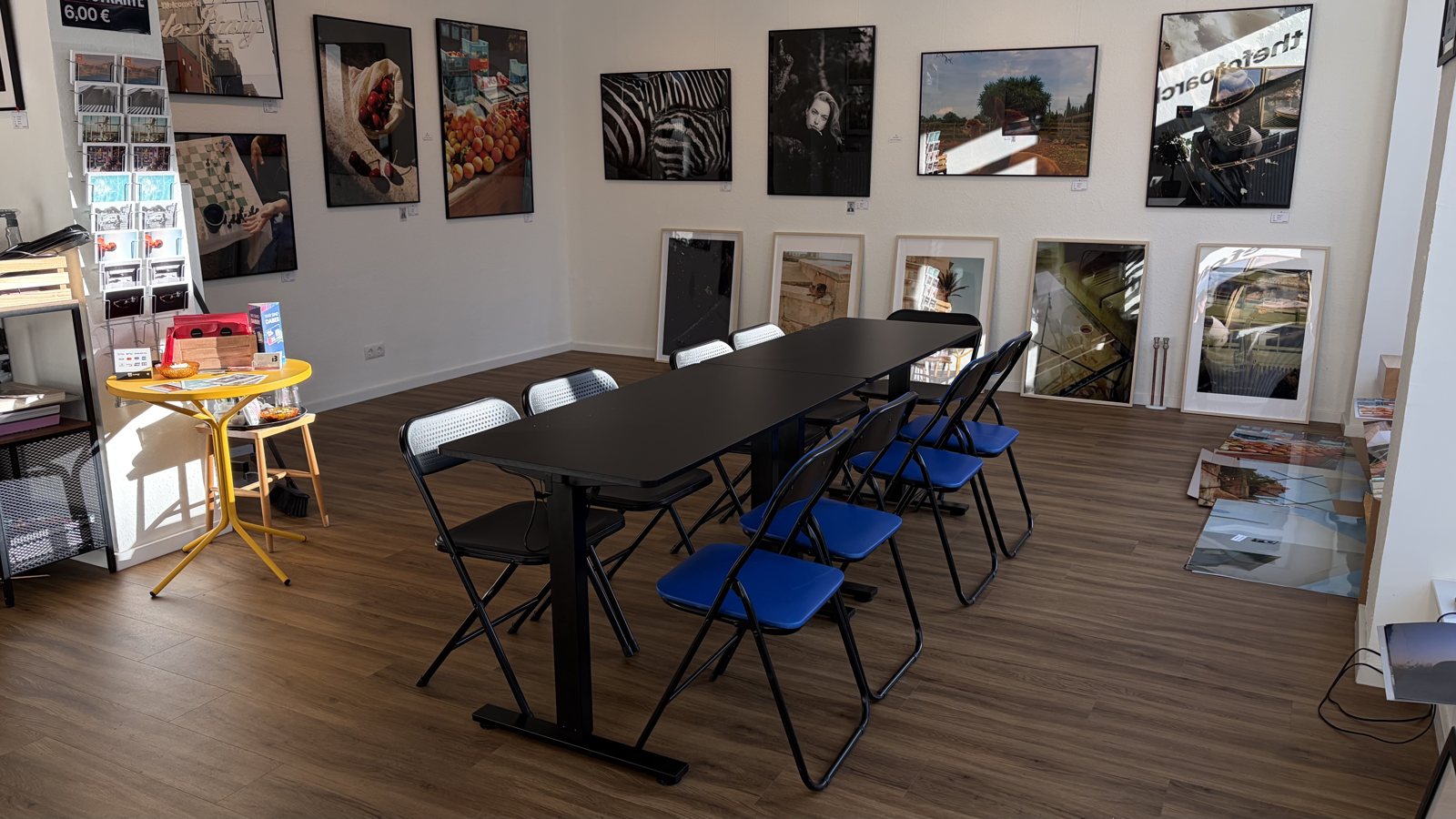 Langer Tisch und Stühle im thefotoarchive, umgeben von Fotografien